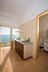 a kitchen with a sink and a view of the ocean at Petalides Apartments in Parikia