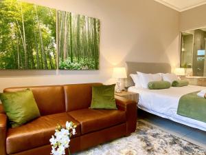 a hotel room with a bed and a couch at Menlyn Maine Residences - Kyoto king size xl bed in Pretoria