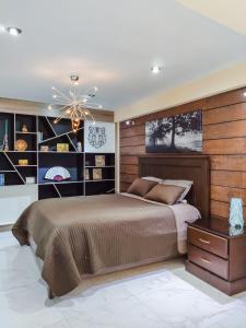 a bedroom with a large bed and a chandelier at Las vistas - Departamento independiente in Cochabamba