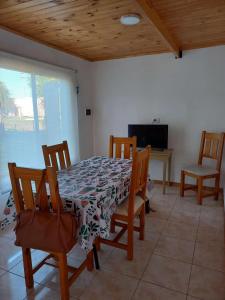 a dining room with a table and chairs and a tv at El Pino in Trenque Lauquen +9 photos
