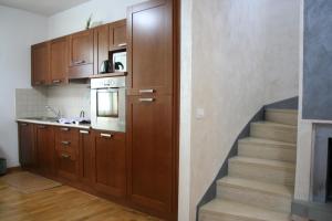 a kitchen with wooden cabinets and a staircase at La Taverna di Sophie in Serre di Rapolano