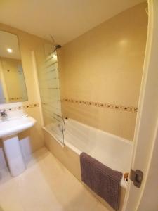 a bathroom with a bath tub and a sink at Cálido apartamento con gran terraza y vistas a 600 metros del mar in Benalmádena