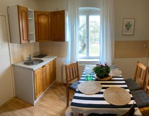 uma cozinha com uma mesa com 2 cadeiras e um lavatório em Ruciane Wianki DOM W SERCU WARMII em Purda