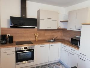 a kitchen with white cabinets and a sink at Kinderbauernhof Wachmann in Rohrbach am Kulm