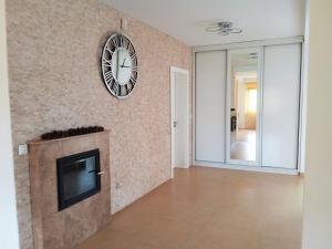 a living room with a tv and a clock on the wall at Casa Panoramic in Turda
