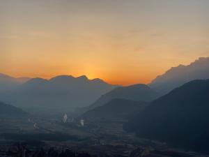 una puesta de sol sobre un valle con montañas en B&B Monte Tesobo, en Roncegno