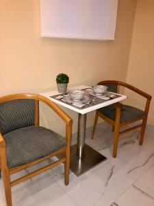 a table with two chairs and a table with bowls on it at Bright, big room in the center of Skiathos in Skiathos Town