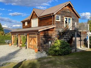 a log cabin with a staircase in front of it at Three Thirty B & B in Queenstown