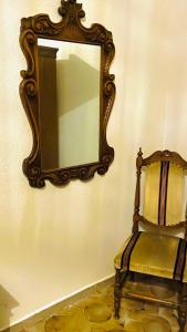 a mirror on a wall next to a chair at Airport Torre Clementina INN in Fiumicino
