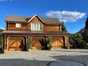 a wooden house with two garage doors in front of it at Three Thirty B & B in Queenstown