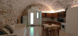 een keuken met een tafel en stoelen in een kamer bij PIETRAVIVA Housing in Molfetta