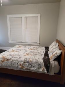 a bedroom with a bed with a comforter and two windows at Luxurious 3 bedroom near downtown in San Antonio