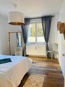 蓬塔利耶Appartement 2 chambres avec terrasse vue sur jardin arboré的一间带床、窗户和椅子的卧室