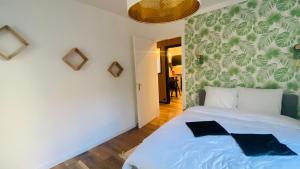 蓬塔利耶Appartement 2 chambres avec terrasse vue sur jardin arboré的一间卧室配有蓝色的床,拥有绿色和白色的墙壁
