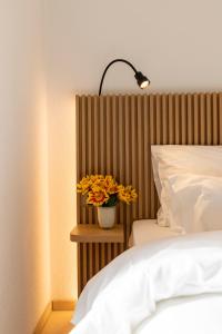 a bedroom with a bed and a vase with yellow flowers at River Residence in Baden