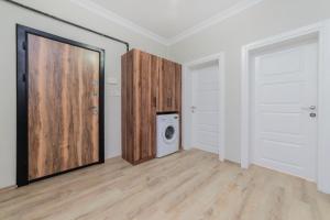 a laundry room with a washing machine and a door at Fresh apartment in authentic neighborhood in Bursa