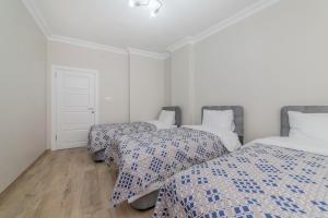 a bedroom with two beds with blue and white sheets at Fresh apartment in authentic neighborhood in Bursa