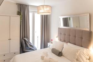 a bedroom with a large white bed with a large mirror at The Perfect Room Zadar in Zadar