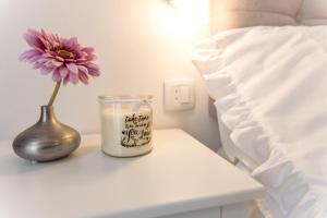 świeca i waza na stole obok łóżka w obiekcie The Perfect Room Zadar w mieście Zadar