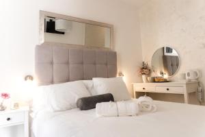 a white bedroom with a large white bed with a mirror at The Perfect Room Zadar in Zadar