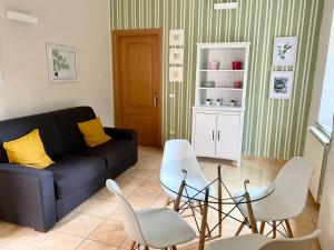 een woonkamer met een zwarte bank en witte stoelen bij Rifugio della Cascata in Collestatte