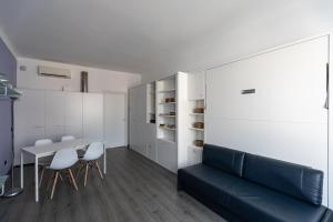 a living room with a couch and a table and chairs at Stresa Residence in Stresa
