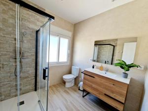 a bathroom with a toilet and a sink and a shower at Burbujas Manchegas in El Toboso