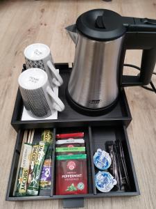 a black tray with a tea kettle and food at Hotel Zu Freunden in Hamm