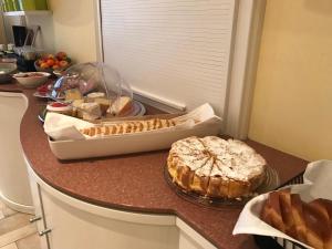 - un comptoir de cuisine avec un gâteau et du pain dans l'établissement Domaine de Mont-Renaud, à Boncourt