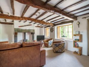 a living room with a couch and a fireplace at Kentmere Fell Views in Kendal