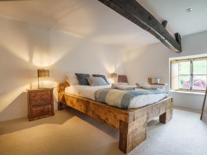 a bedroom with a large wooden bed and a window at Kentmere Fell Views in Kendal