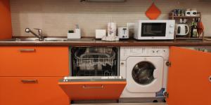 a kitchen with a washing machine and a microwave at Terrazza di San Paolo in Rome