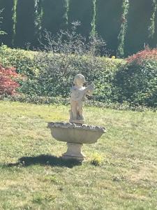 a statue of a child sitting on top of a fountain at Domaine de Mont-Renaud in Boncourt