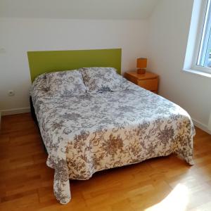 Un dormitorio con una cama con una manta. en Appartement Calme Et Lumineux en Radinghem-en-Weppes
