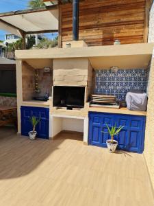 a kitchen with blue cabinets and a counter with plants at Casa Sacy in Villajoyosa