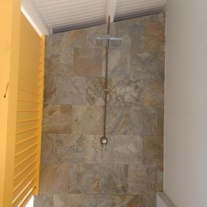 uma casa de banho com uma parede de pedra em Maison de vacances les pieds dans l'eau em Schœlcher