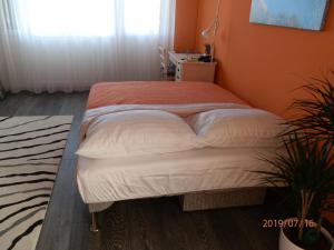 a bed in a room with an orange wall at Apartment RINO****, 58m², 170m from the beach in Rijeka