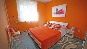 a bedroom with orange walls and a bed and a chair at Apartment RINO****, 58m², 170m from the beach in Rijeka +51 photos