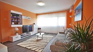a living room with orange walls and a large window at Apartment RINO****, 58m², 170m from the beach in Rijeka