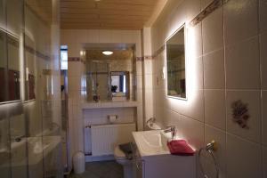 a bathroom with a sink and a shower and a toilet at Auszeit - Ferienwohnung und Appartements in Bad Sooden-Allendorf +21 photos