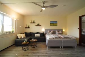 a living room with a bed and a couch at Auszeit - Ferienwohnung und Appartements in Bad Sooden-Allendorf