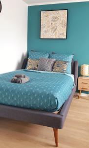 a bed in a room with a blue wall at The Scandinavian - Elegance et simplicité ! in Dreux