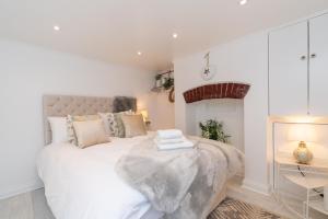 a bedroom with a large white bed with towels on it at Central Apartment - with Patio and Sofa Bed! in Cheltenham