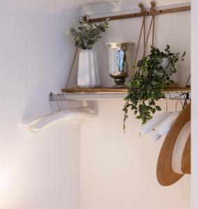 une étagère avec des vases et des plantes sur un mur dans l'établissement Central Apartment - with Patio and Sofa Bed!, à Cheltenham