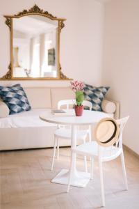 una mesa blanca y sillas en una sala de estar con sofá en Casa Cavour, en Garda