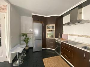 a kitchen with a stainless steel refrigerator and a sink at Casa Lúa in Castro Caldelas