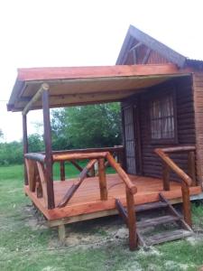 una gran terraza de madera con una casa pequeña en Chacra Mandala en Gualeguay