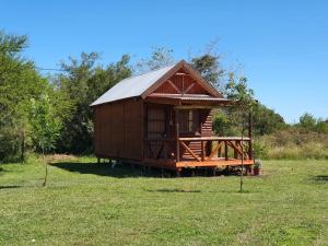 a small wooden cabin in a field of grass at Chacra Mandala in Gualeguay