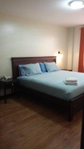 a bedroom with a bed with blue pillows at HOTEL CENTRAL in El Tambo