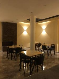 a dining room with tables and chairs and lights at HOTEL CENTRAL in El Tambo
